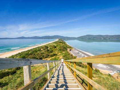 Man walking up long staircase by the ocean in Tasmania