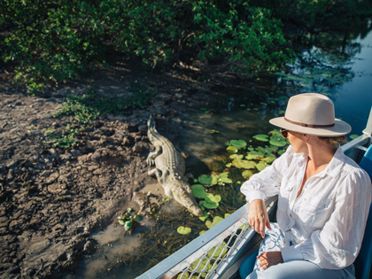 Woman on a Yellow Water boat cruise viewing a crocodile