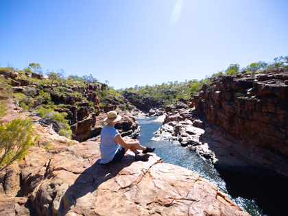 Woman sitting on the edge of a gorge in the outback