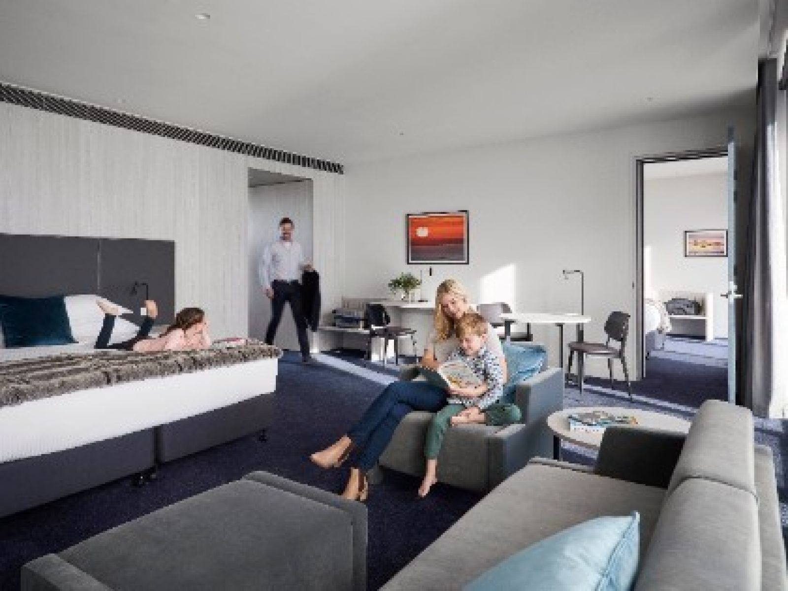 A happy family enjoying time together inside the Deluxe Family Room at RACV Cape Schanck Resort