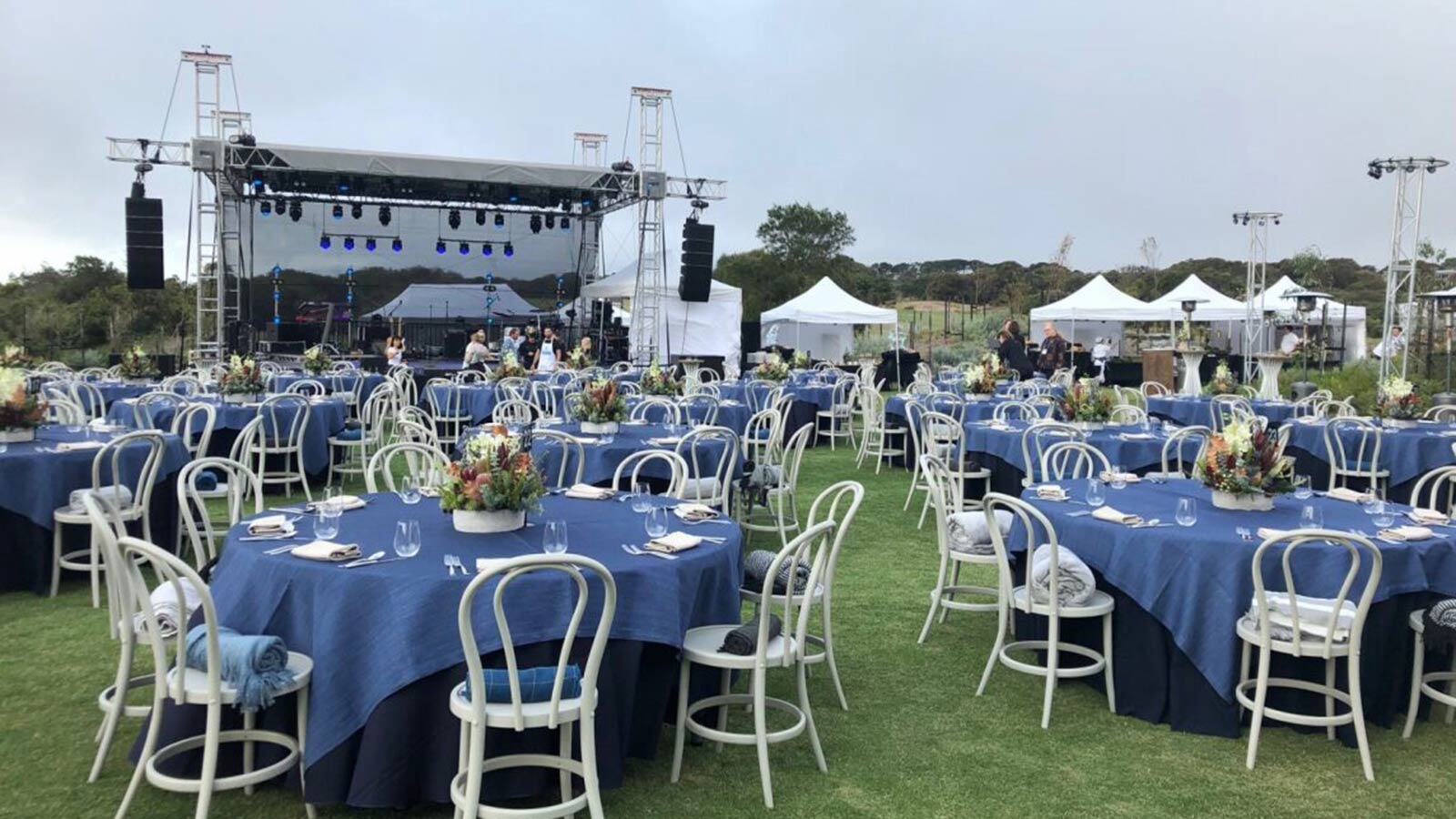 Stage, white tents and tables set up banquet style outside RACV Cape Schanck Resort. 