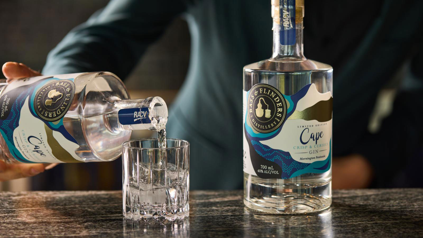 A hand puring some Gin from a bottle. 