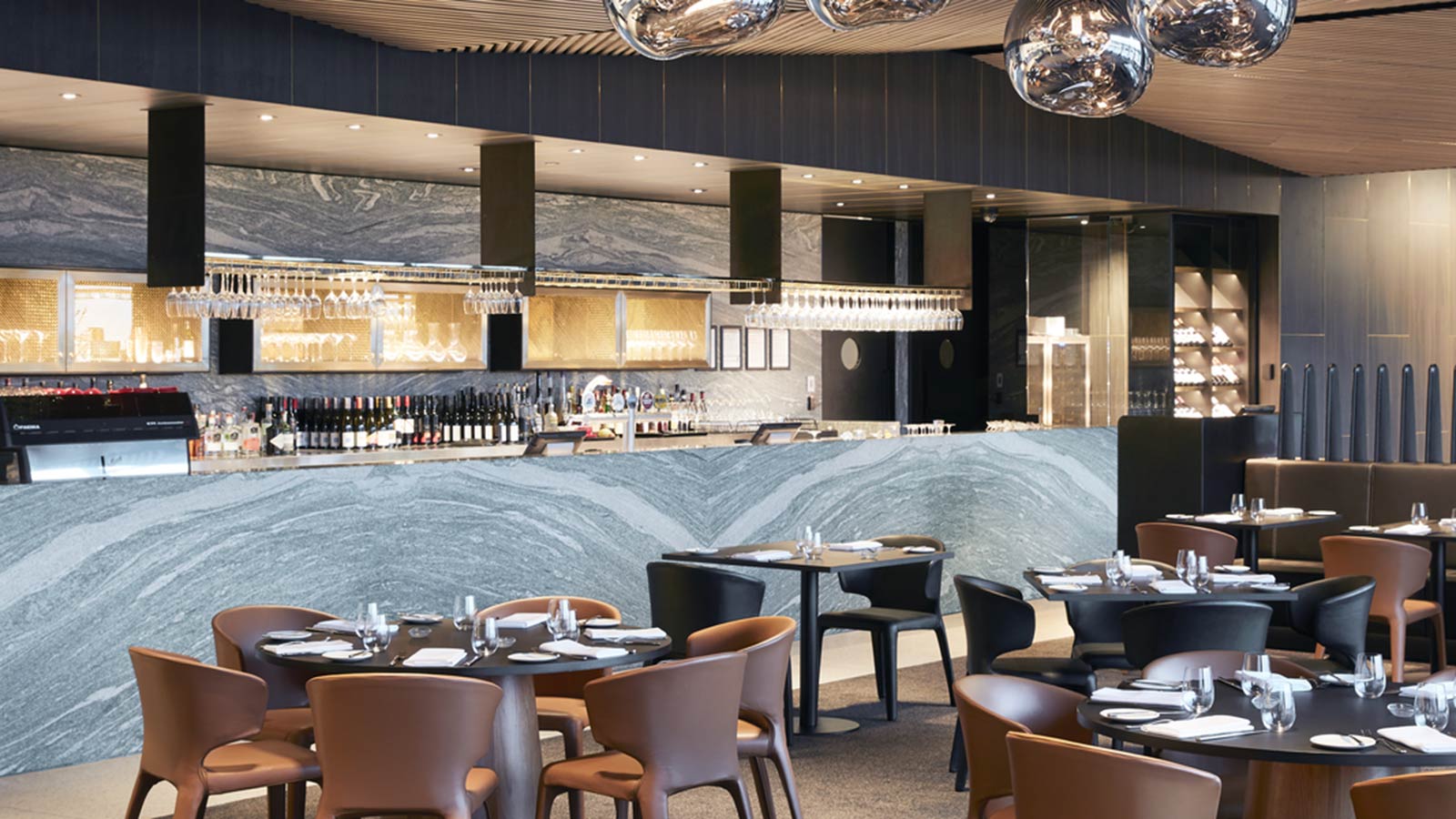 Samphire restaurant at RACV Cape Schanck Resort, with round tables set up for dinner in front of the bar.