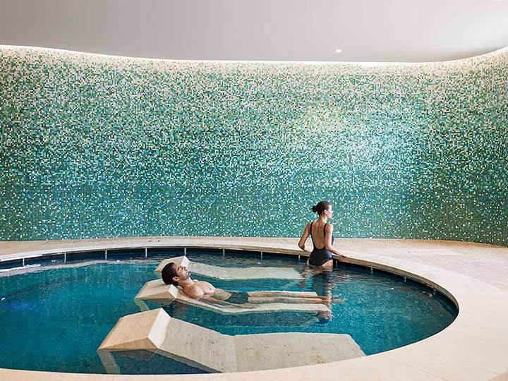 Two people in a pool with day beds at Cape Schanck One Spa.