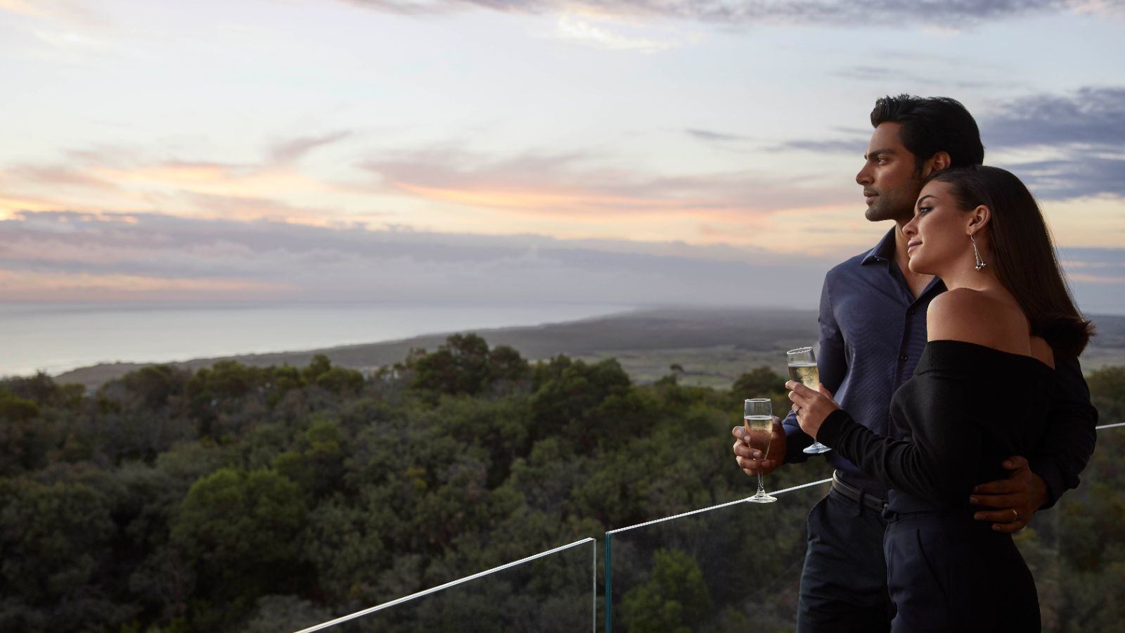 Couple drinking champagne on balcony.