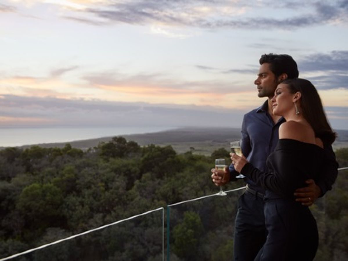 Couple drinking champagne on balcony.