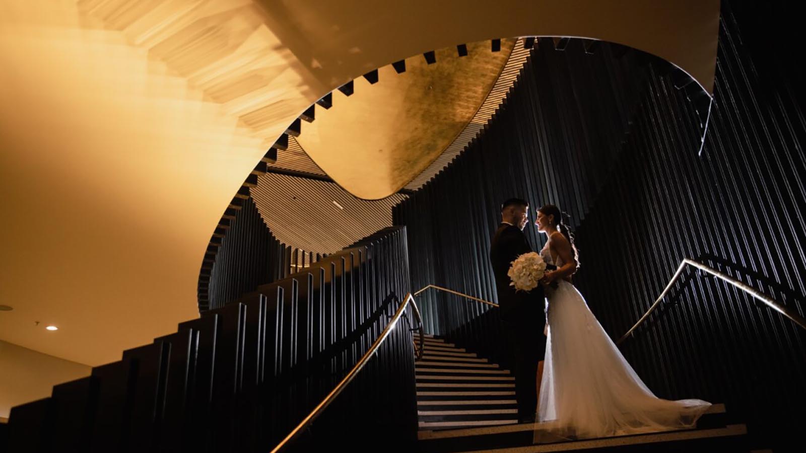 Bride and groom posing on spiral staircase at RACV Cape Schanck resort.