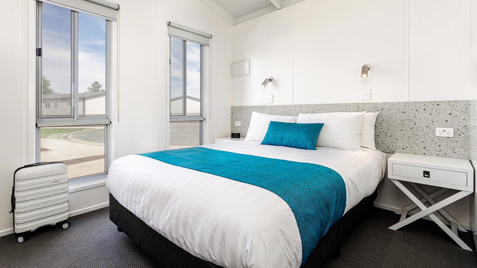 Bedroom in RACV Cobram Resort's Deluxe Park Cabin, featuring a queen bed and two bedside tables.