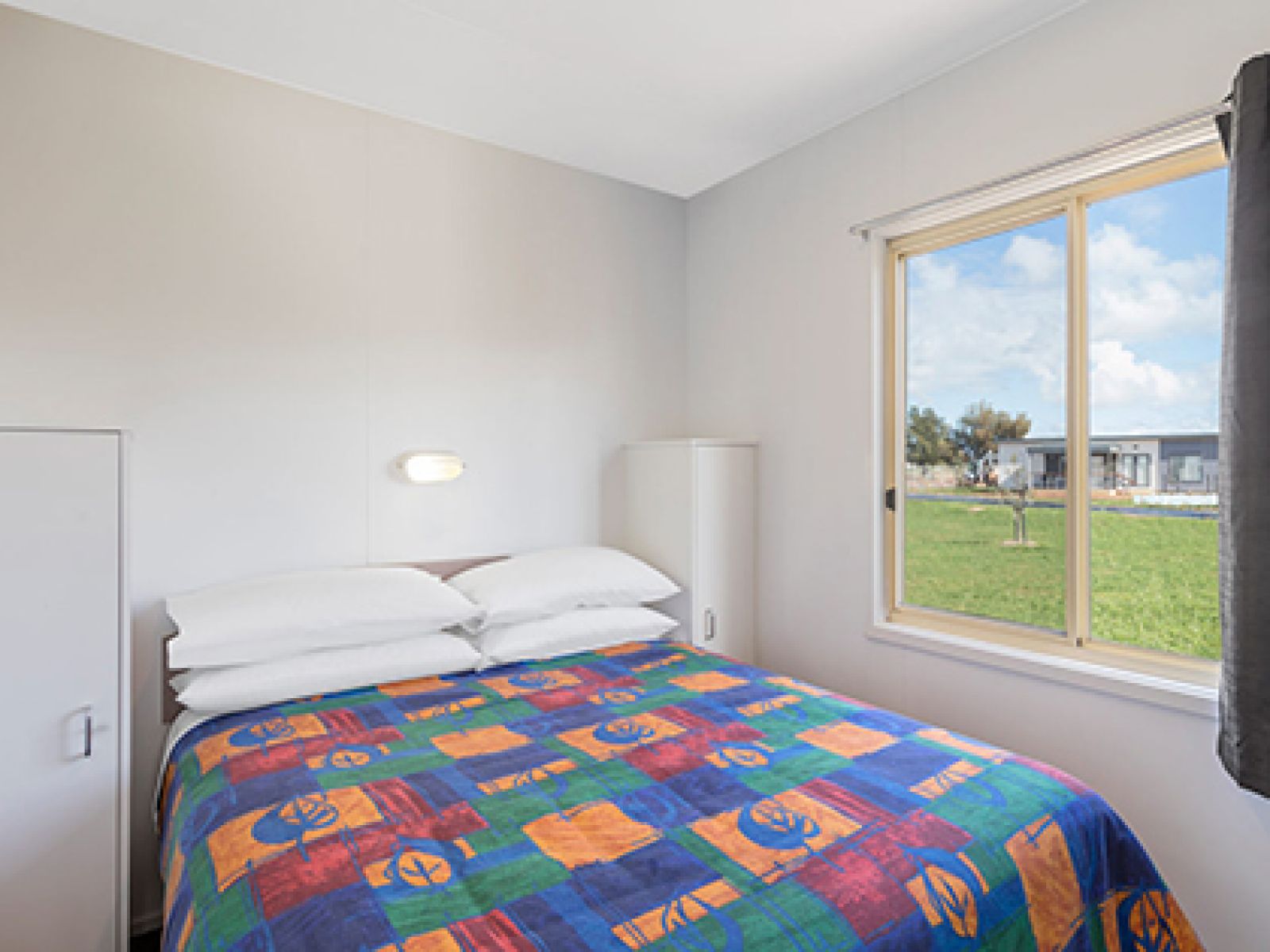 Double bed in bedroom of park cabin at RACV Cobram Resort.