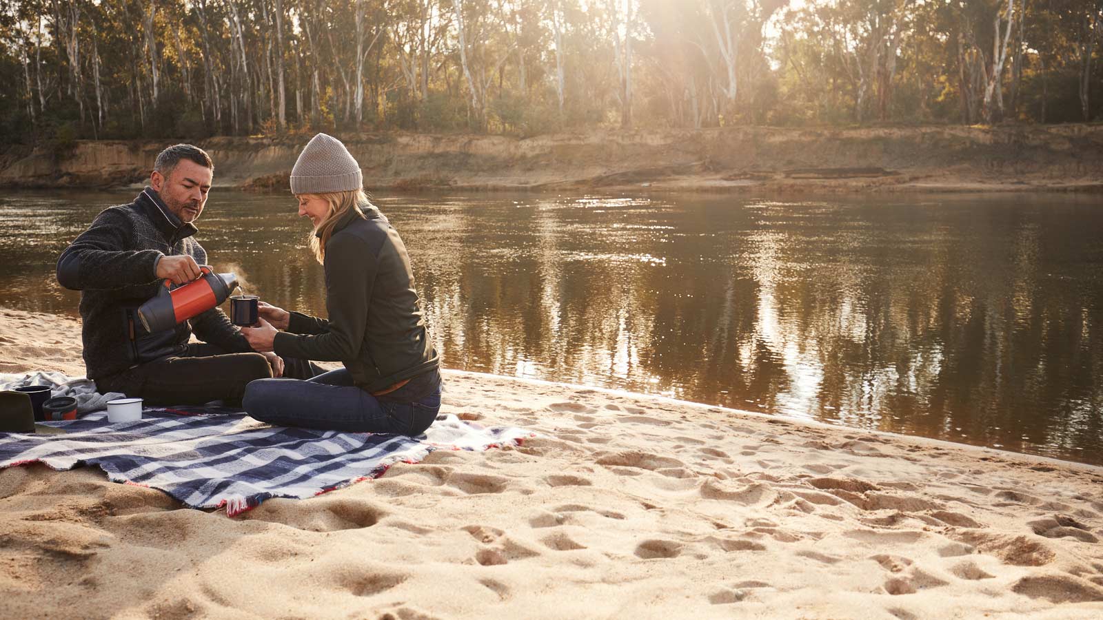 A couple having a picnic next to the Murray River