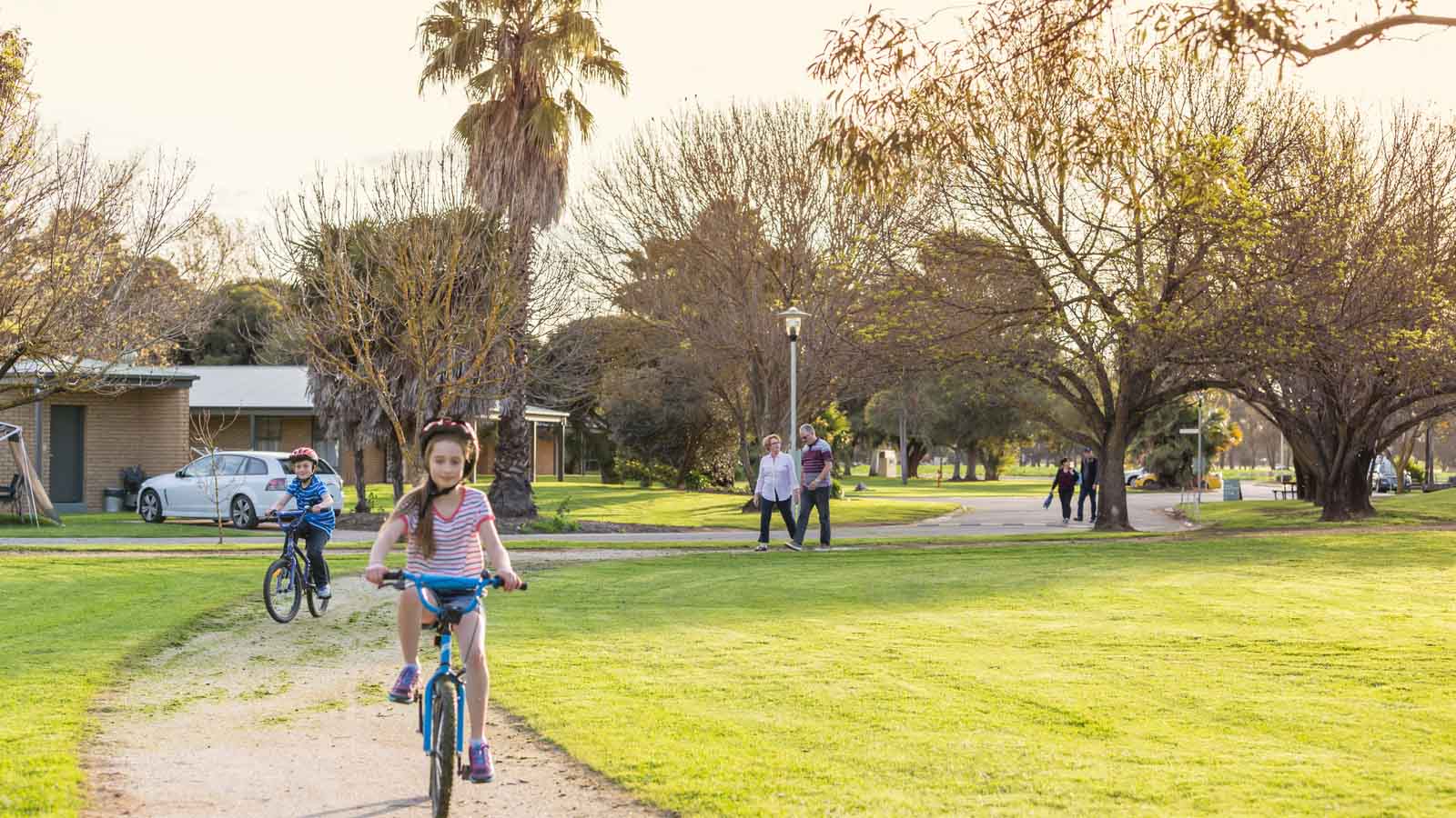 A girl and boy riding on the shared path at the Cobram resort.