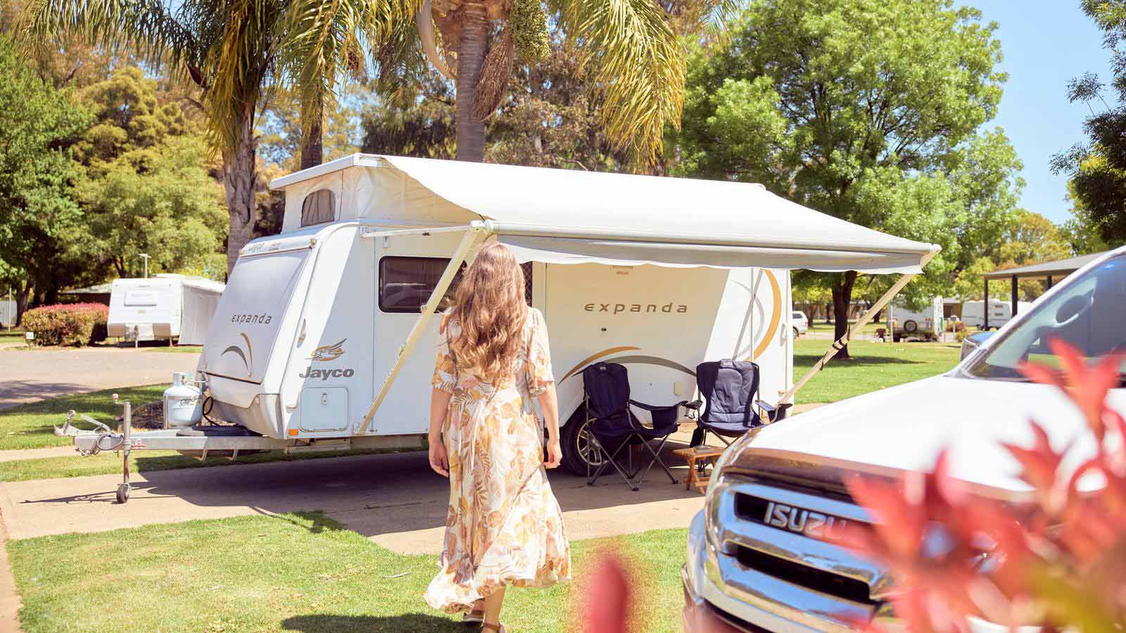 Woman walking towards a caravan.