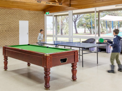 Rwo young kids playing ping pong in the games room at RACV Cobram.