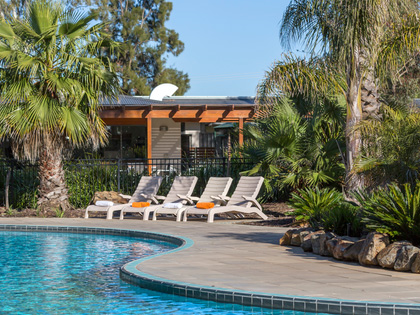 Pool chairs lined up beside the pool on a sunny day. 