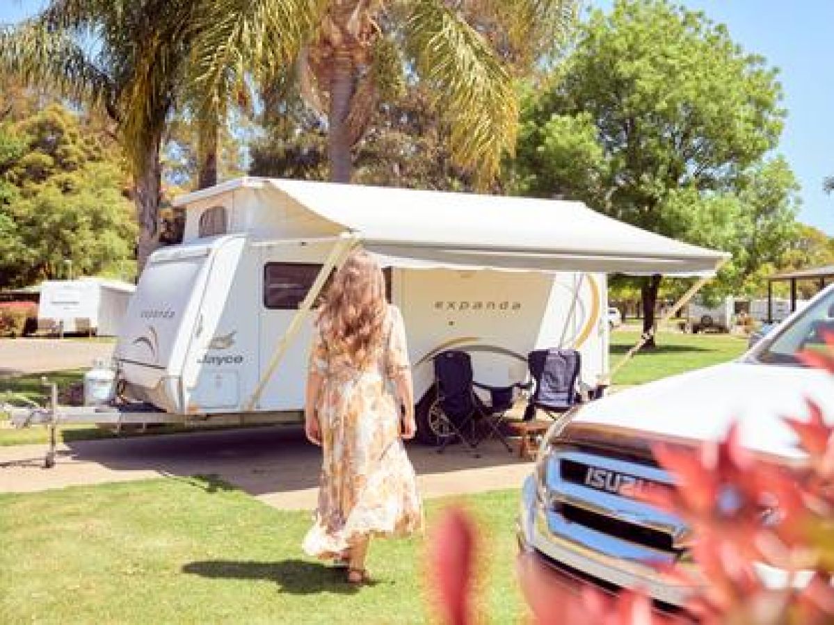 Woman walking towards a caravan.