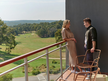 A couple on a balcoelds Resort. ny at Goldfi