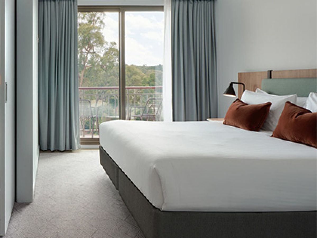 Bed with open window in a studio bedroom at Goldfields