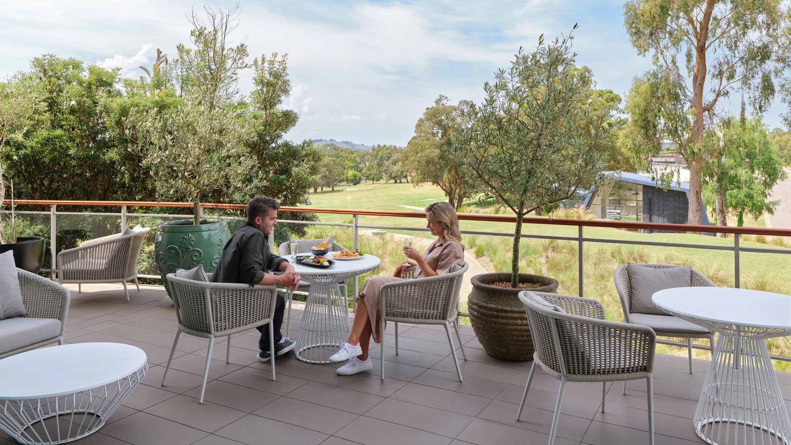 Two people sitting and talking at RACV Goldfields Resort's Springs Bar and Terrace.