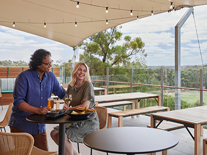 Couple having drinks in beer garden at Three Founders restaurant at RACV Goldfields resort.