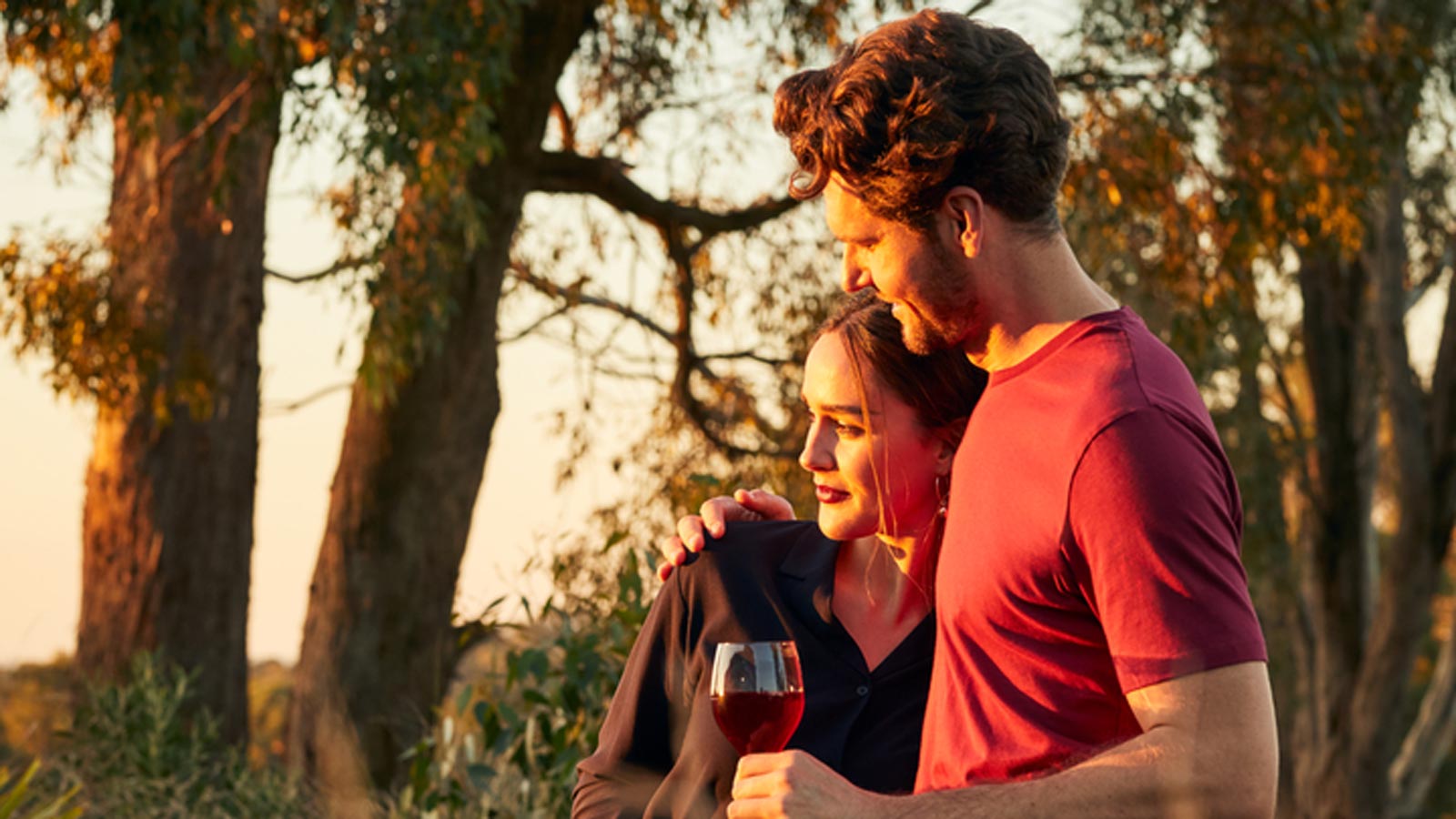 A couple enjoing a glass of wine with the sunset. 