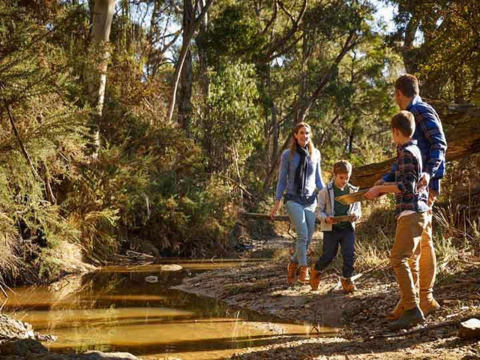 Young family panning for gold on a creekbed.