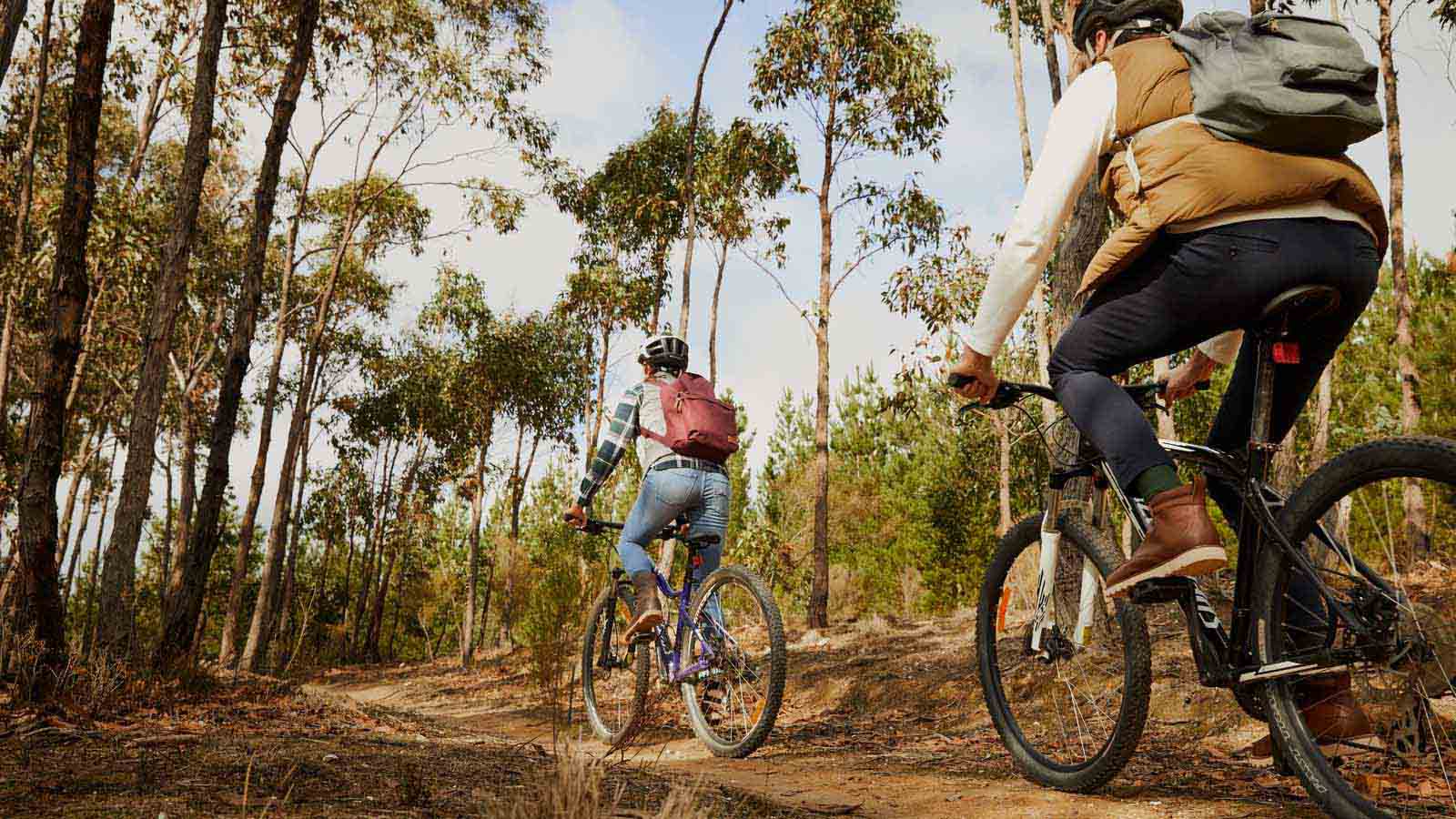 Two people riding bikes on a mountain bike trail near RACV Goldfields Resorts.