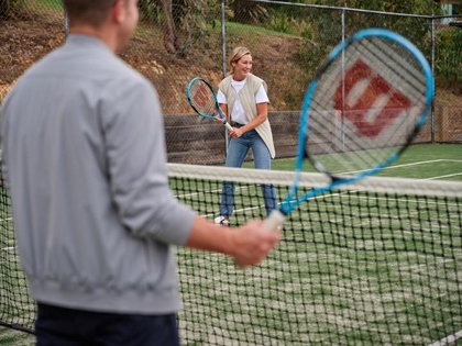 A lady enjoying tennis lessons whilst staying at the Goldfields resort.