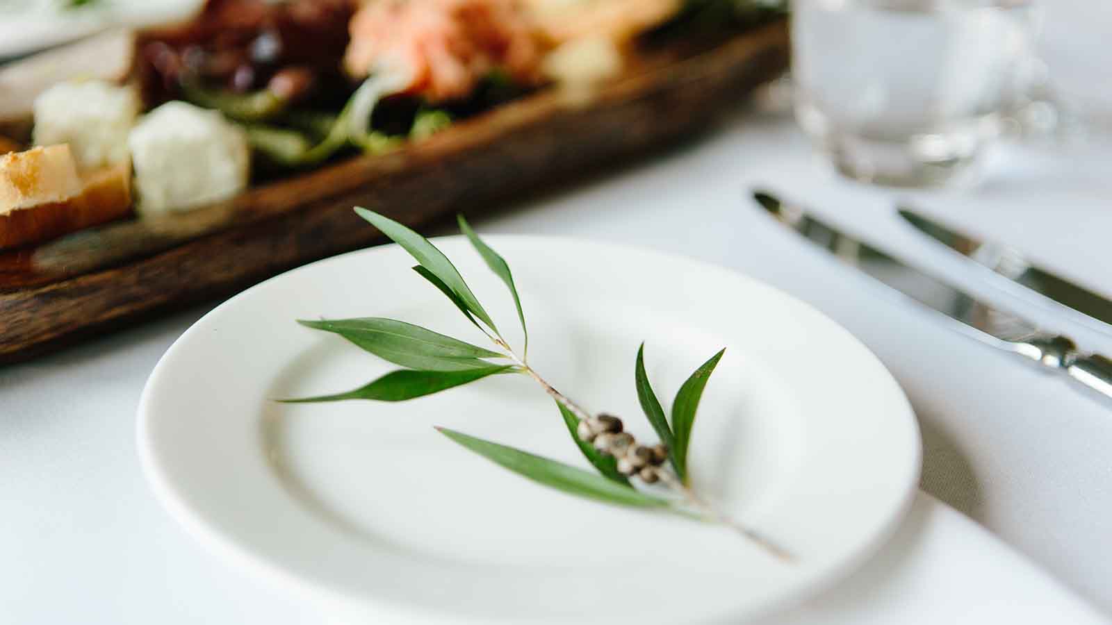Wedding place setting at RACV Goldfields resort, with native leaves on white plate.
