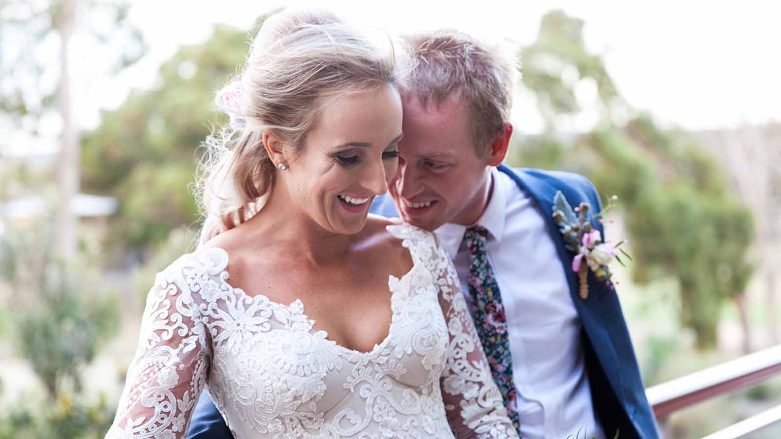 Bride and groom posing in front of greenery at RACV Goldfields resort.