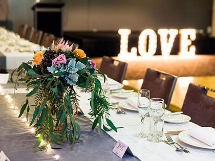Image of wedding table setting at RACV Goldfields Resort, illuminated love sign in the background.