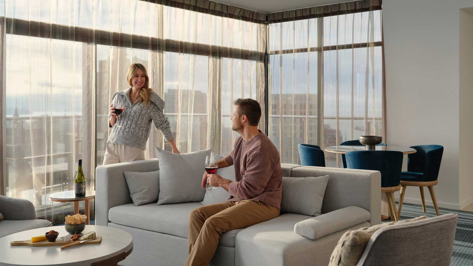 Couple enjoying some wine in the penthouse at RACV Hobart Apartments. 