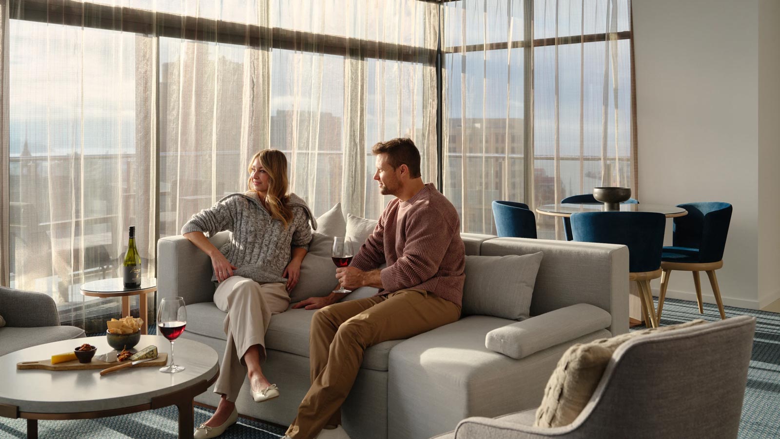 Couple enjoying a glass of wine together in their hotel room