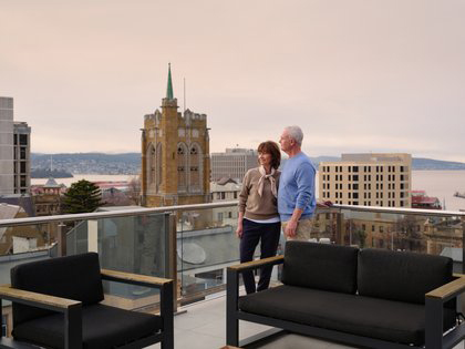 A mature aged couple enjoying the view from the penthouse balcony. 