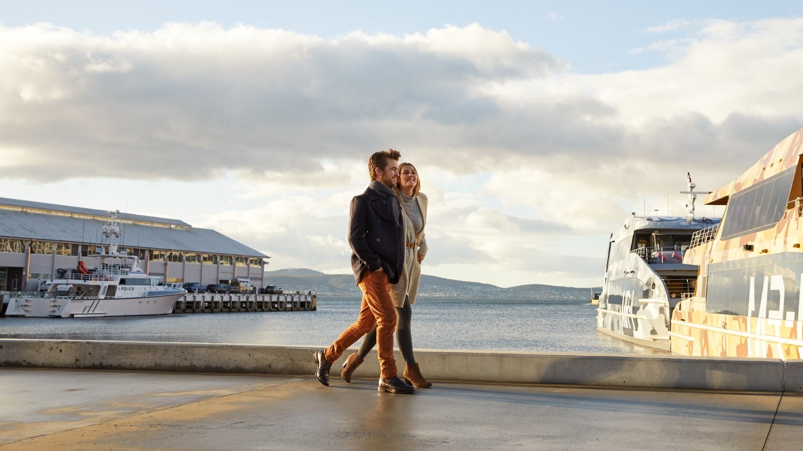 couple walking along the water in hobart