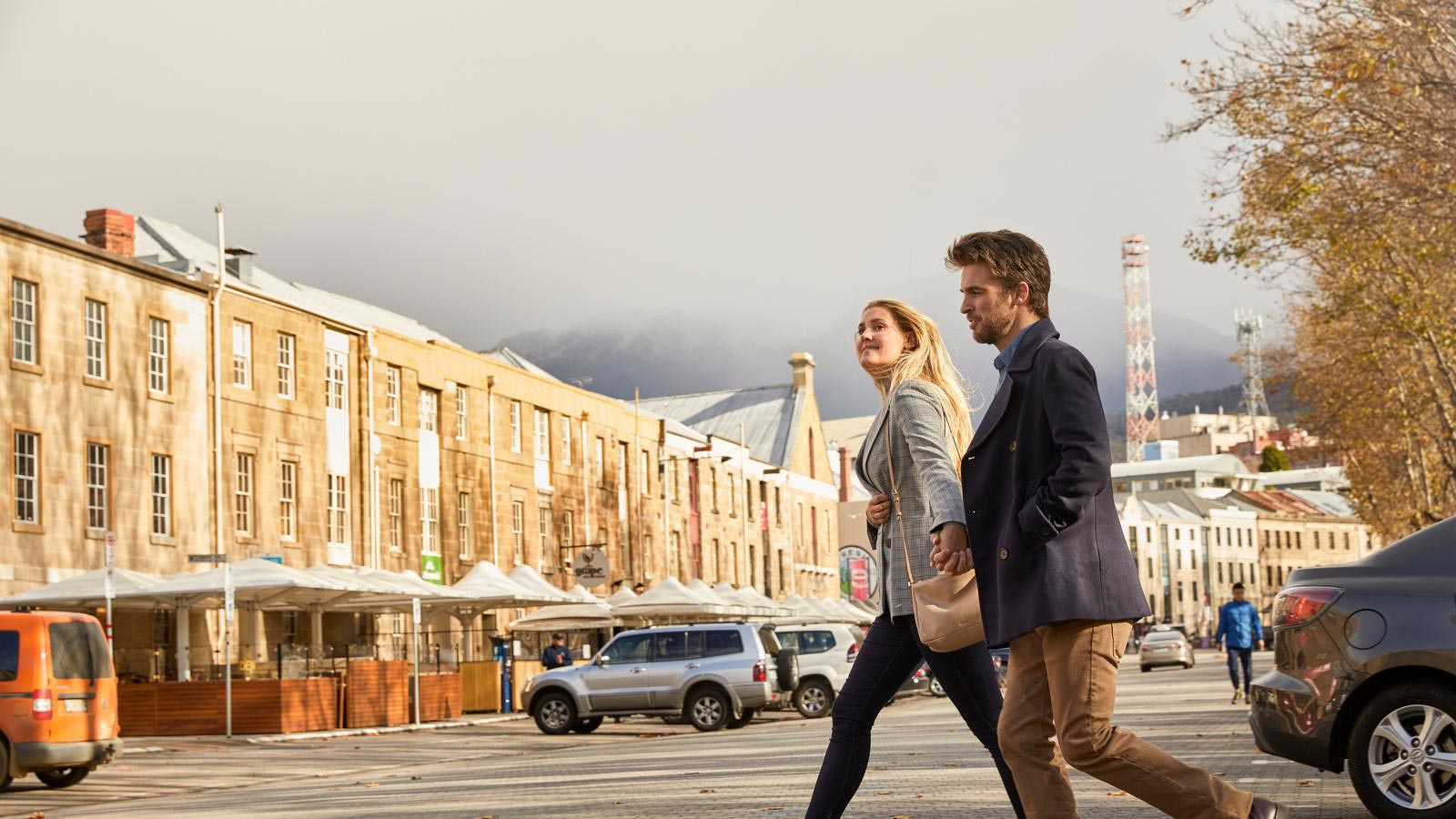 Couple walking through Salamanca streets in Hobart.