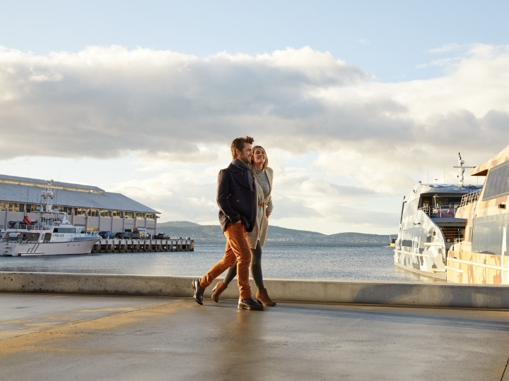 couple walking along the water in hobart