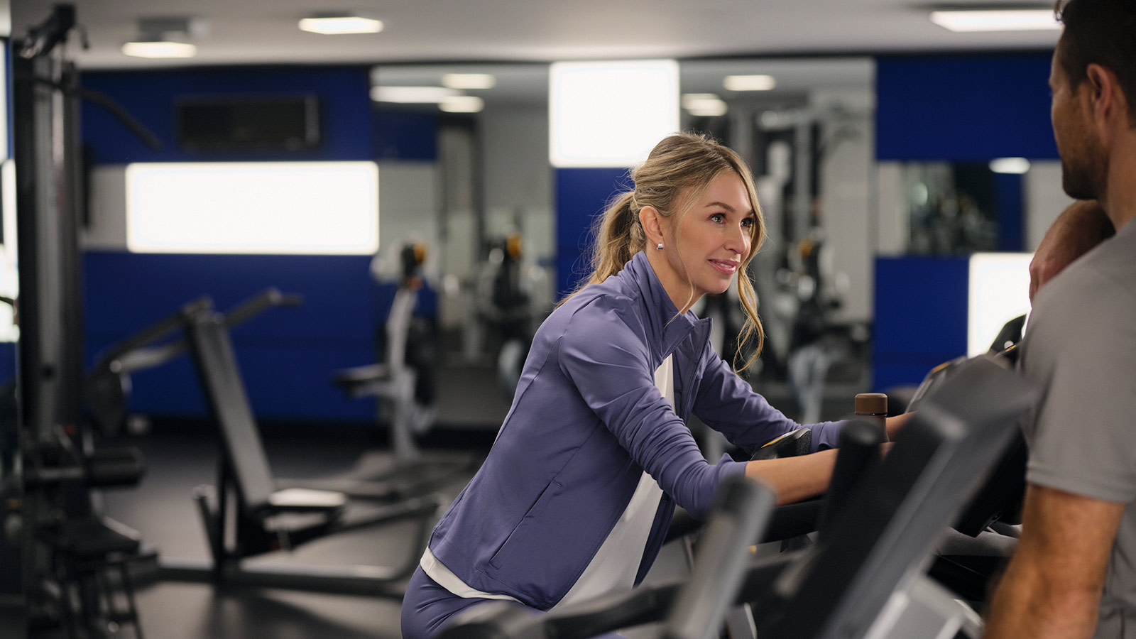 Two people smiling while using the gym facilities at RACV Hobart Hotel.