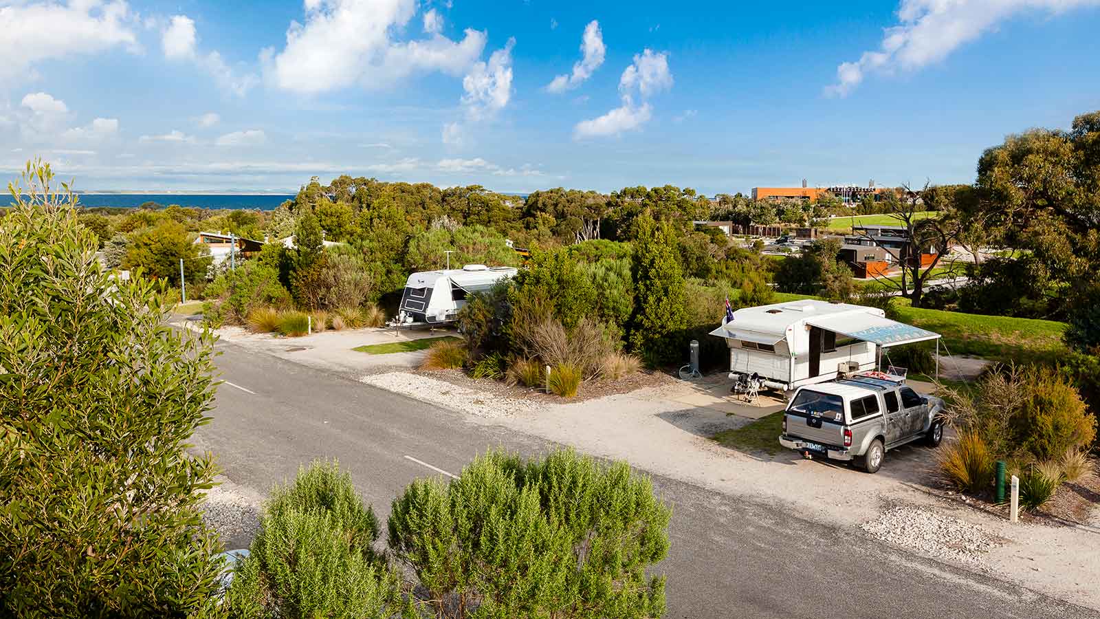 Cars parked RACV Inverloch Resort's caravan site, surrounded by greenery.