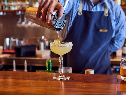 A waiter pouring a cocktail at the bar