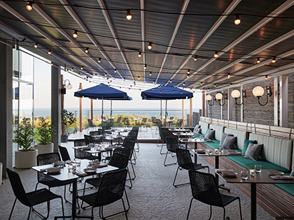 Outdoor dining terrace area at RACV Inverloch Resort, featuring tables and chairs set up in two rows.