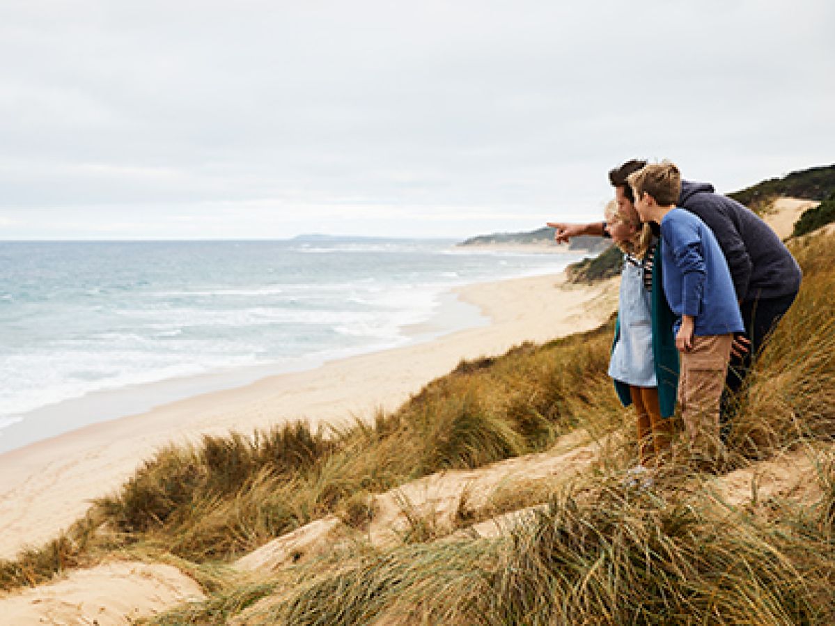 Parent and two kids standing together on the beach near RACV Inverloch Resort.