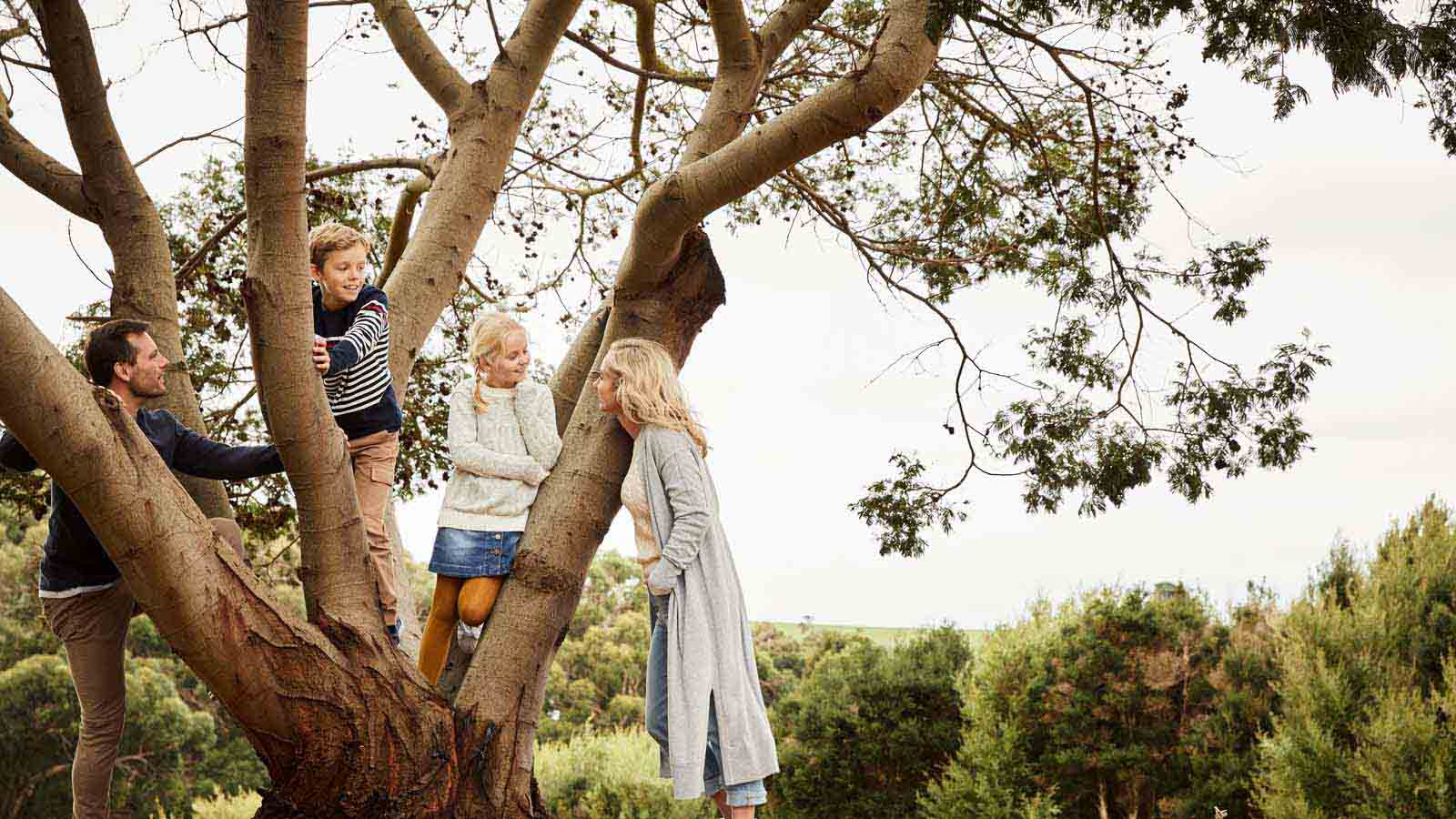 A family playing by a tree at the Inverloch Resort.