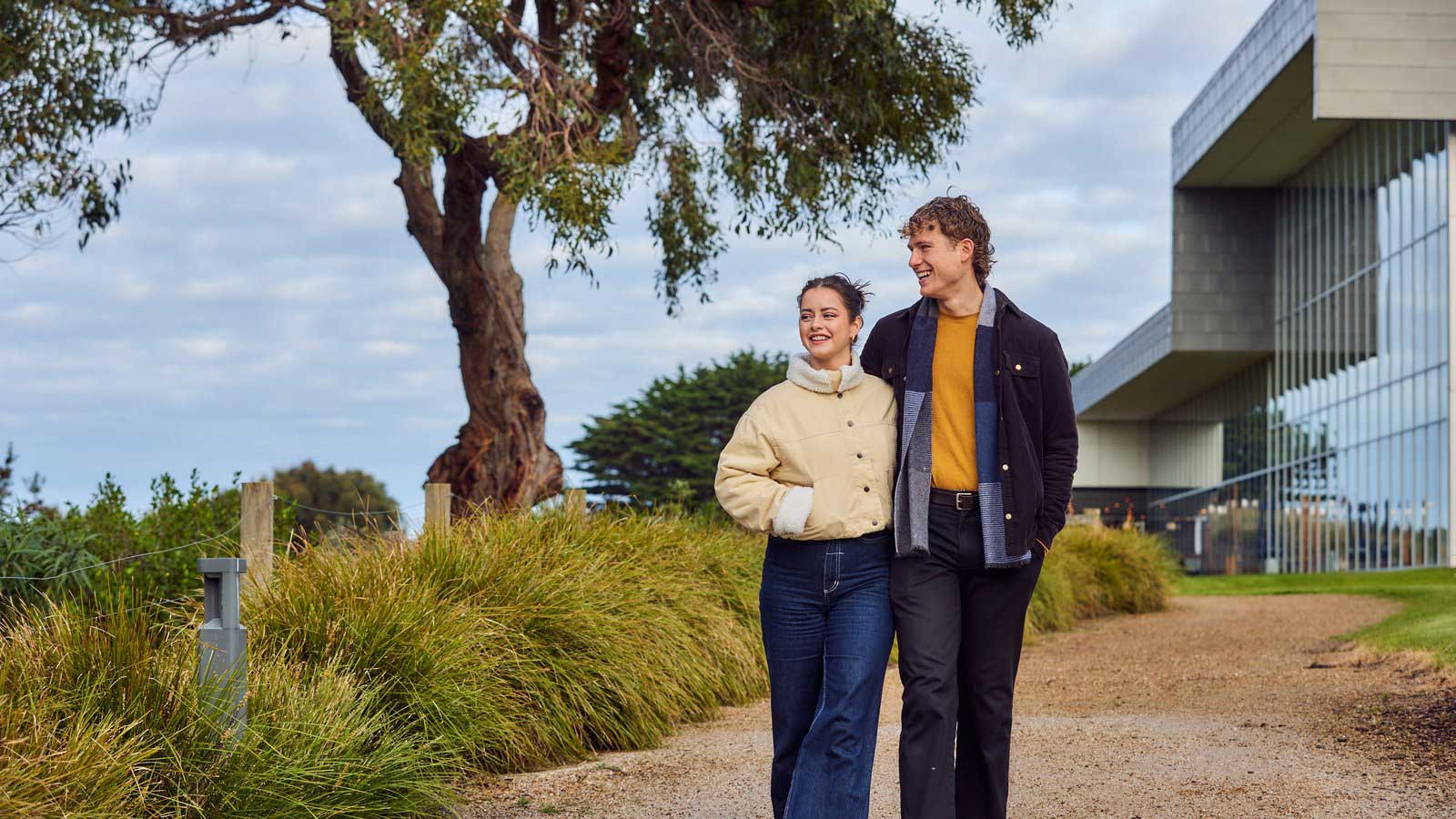 A young couple strolling outside on the grounds of RACV Inverloch resort. 