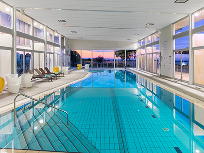Lounge chairs facing the indoor swimming pool at RACV Inverloch Resort.