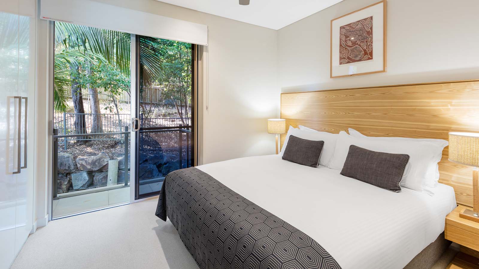 Luxury bedroom in RACV Noosa Resort's precinct villa featuring a king bed and balcony.