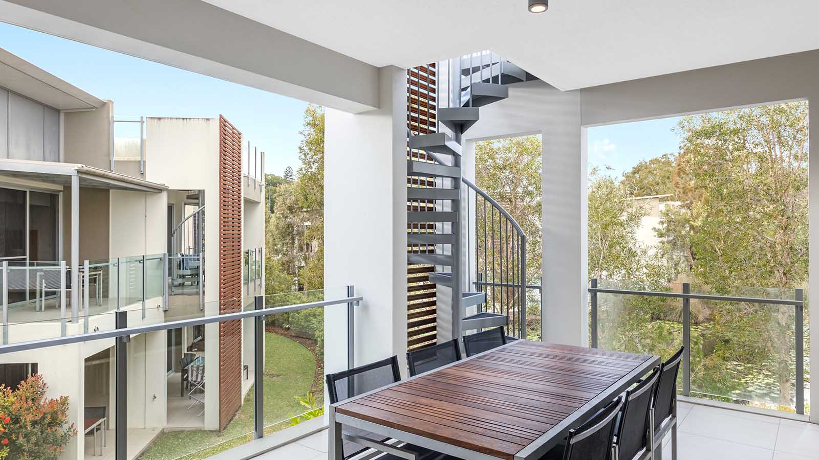 Noosa Resorts balcony with an outdoor table and chairs. 