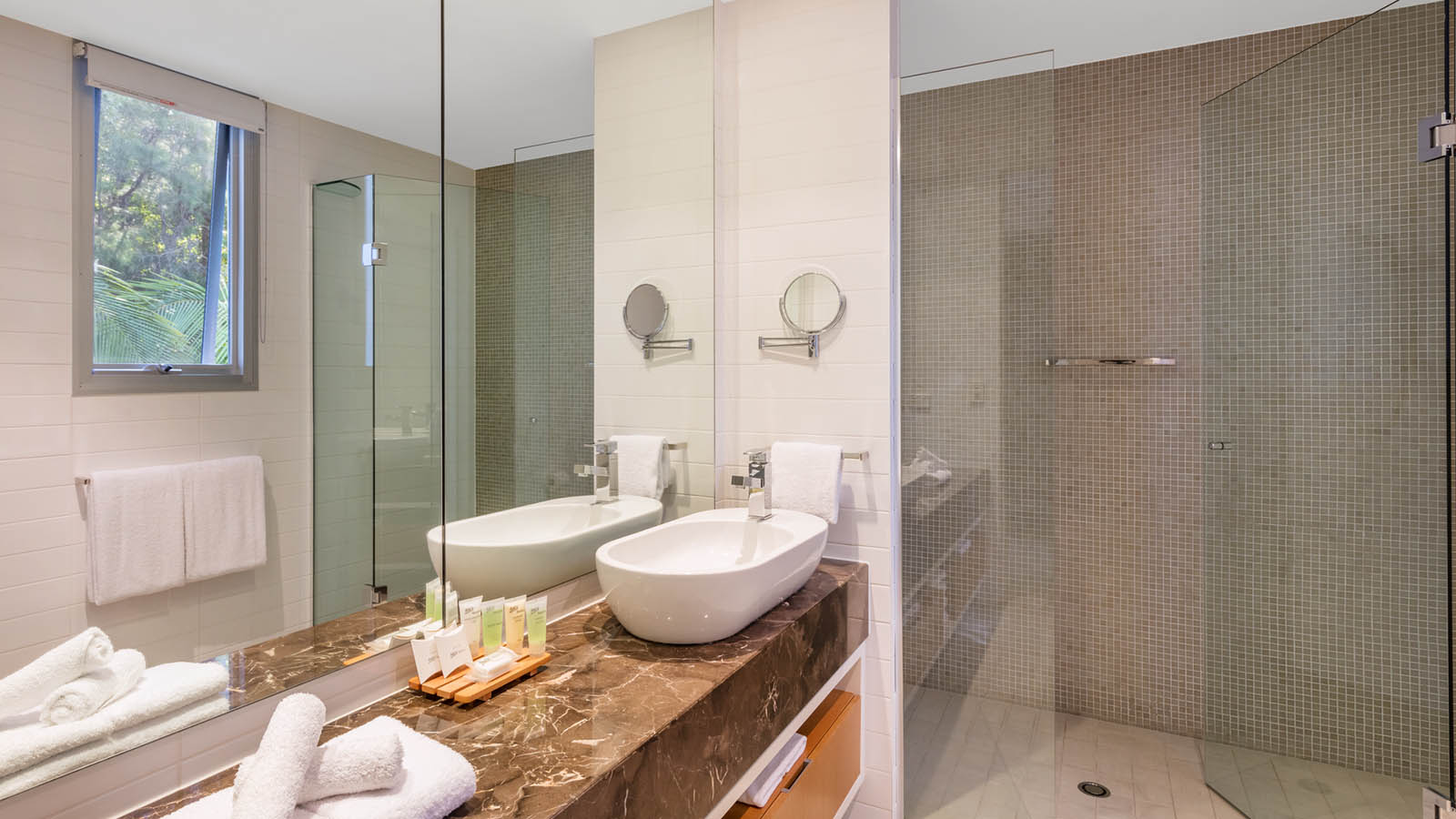 Noosa Resorts Villa bathroom with a spacious shower, sink and mirror. 