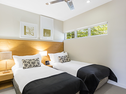 RACV Noosa Resorts two bedroom sanctuary apartment bedroom, featuring twin single beds and modern furnishings. 