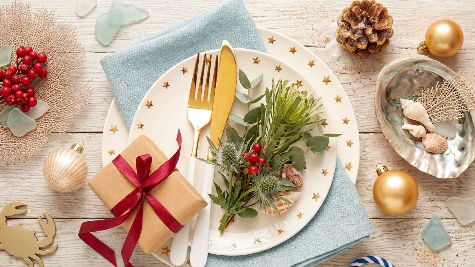 A table decorated with Christmas items and dinnerware