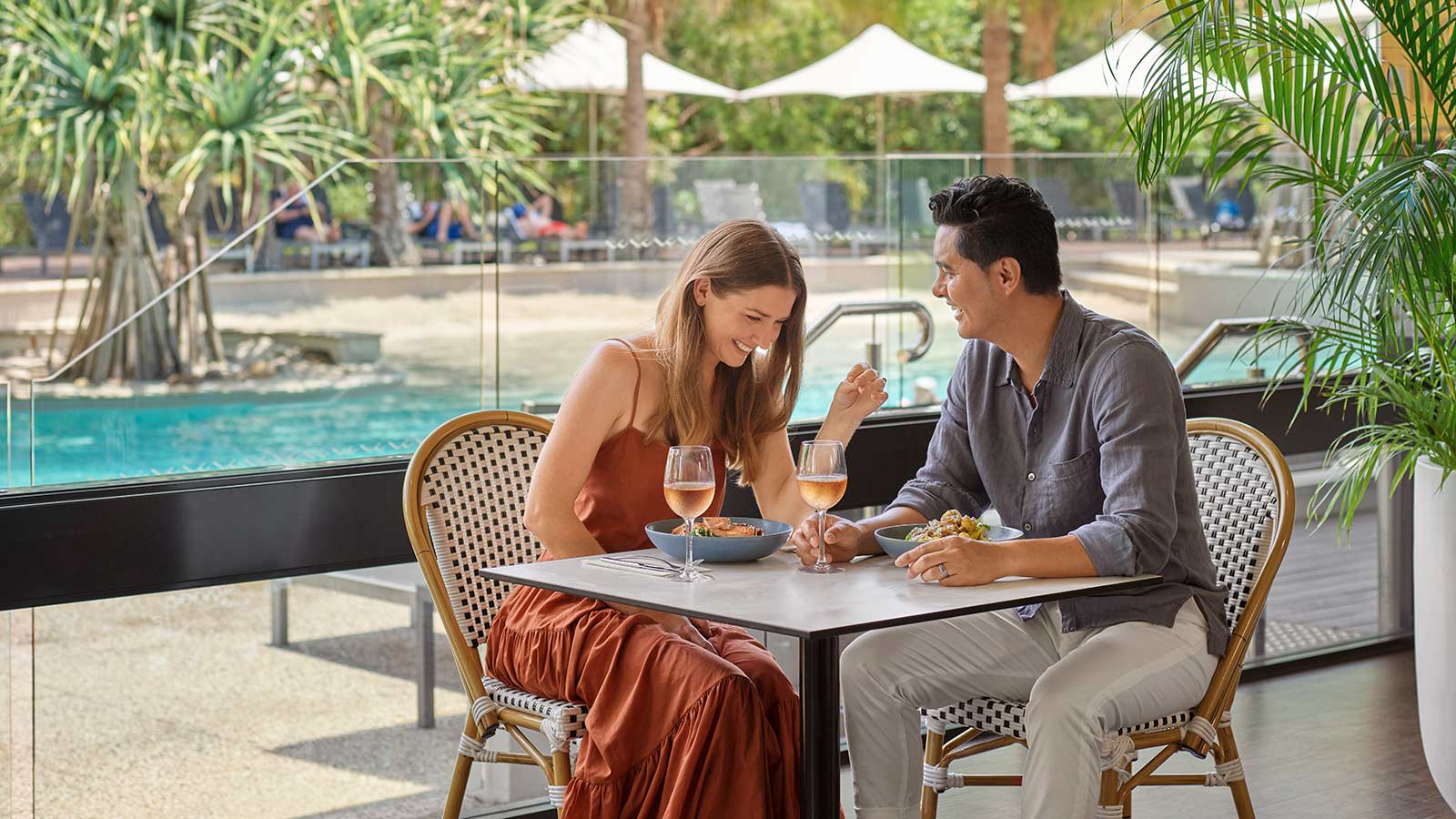 Couple laughing and eating together at Dazza's Bar at RACV Noosa Resort.